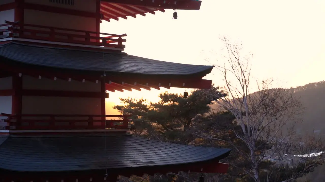 Silhouette of Japanese Pagoda against sunset sky on clear day in slow motion