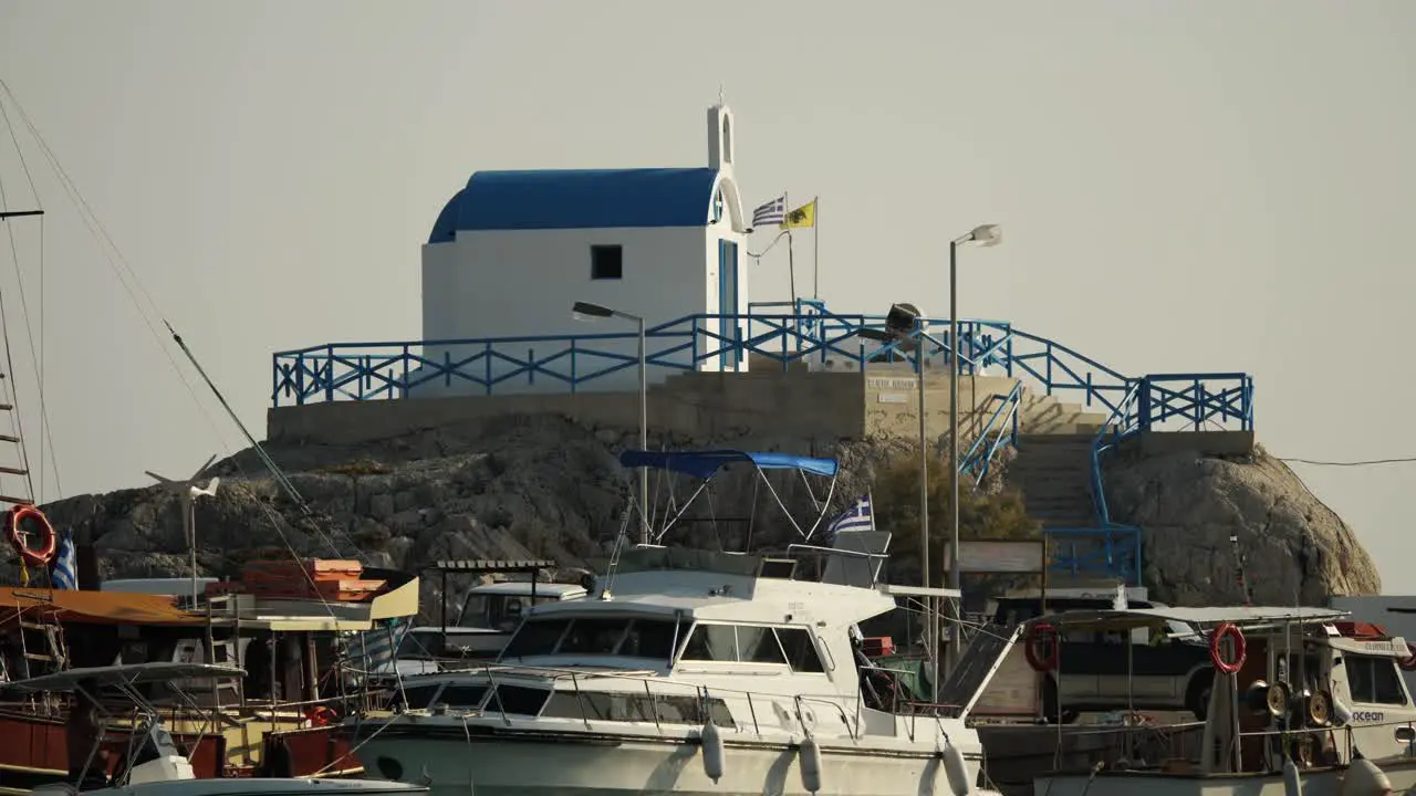 Small orthodox church surrounded by boats at Kolymbia Harbour