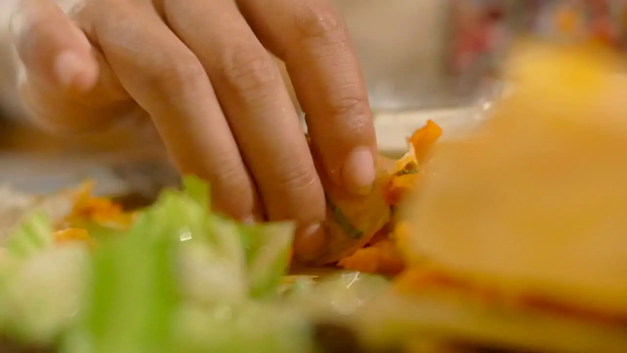 Extreme close up of fingers picking up curry with freshly cooked dosa pancake