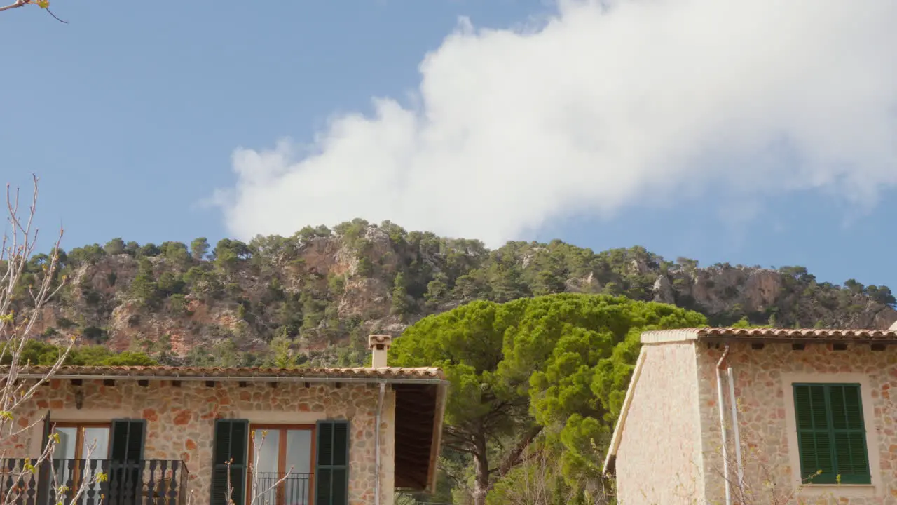 Rooftops of houses in Valldemossa Mallorca Spain set against mountains and a blue sky painting a picturesque townscape