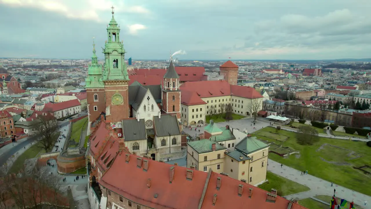 Slow reveal flying backwards over Krakow Wawel Royal Castle moving forward city center fortress with the old town and Cracow skyline