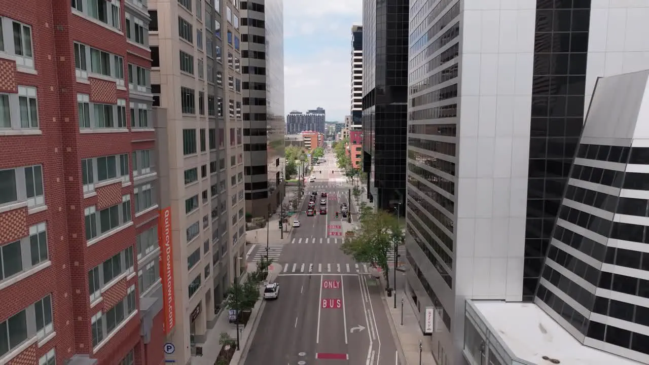 Drone flying in Denver downtown between city skyscrapers sunny day in United States