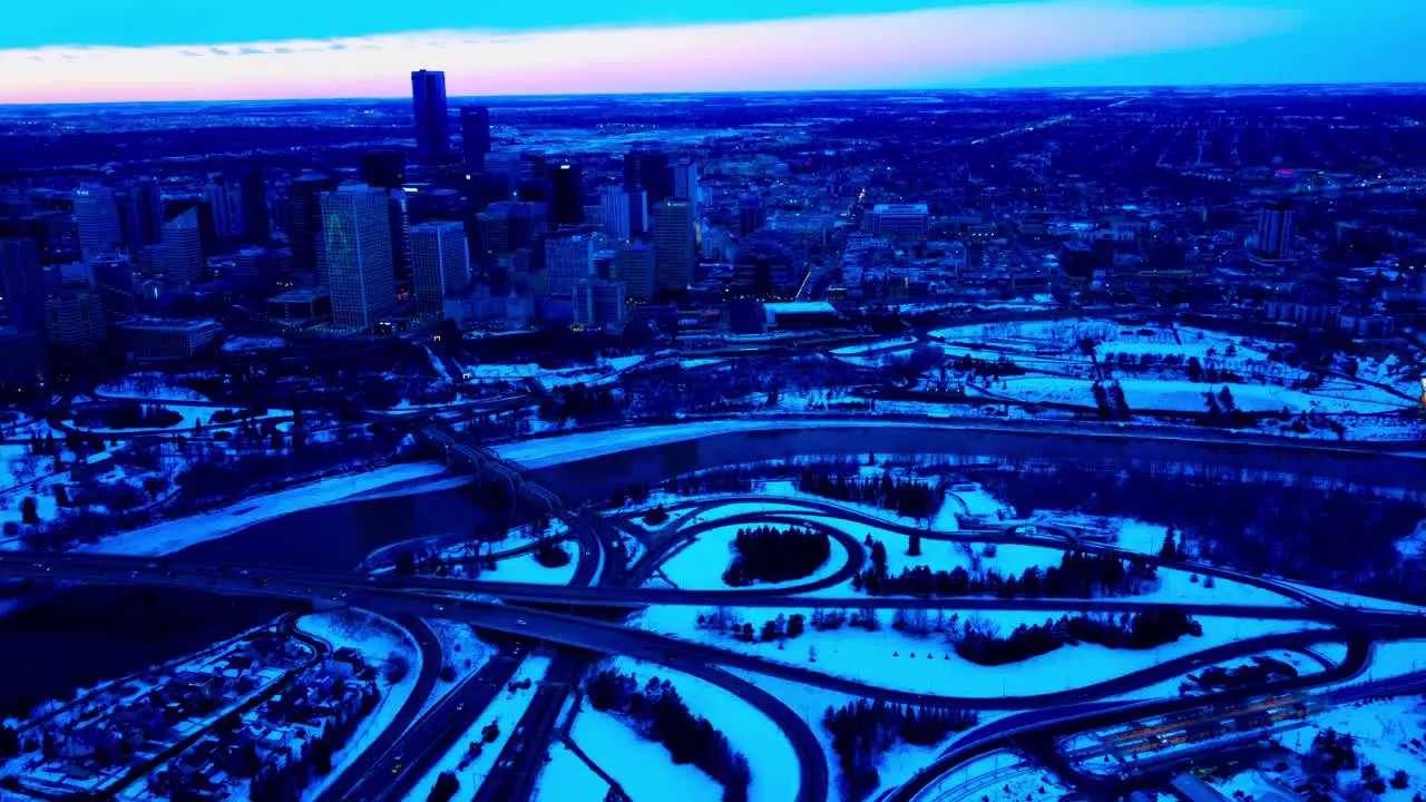 Winter Downtown City of Edmonton Sunset reverse flight pan out of downtown East side over the rivers edge classic iconic Low Level and James MacDonald Bridges with snow covered Riverdale community 1-2