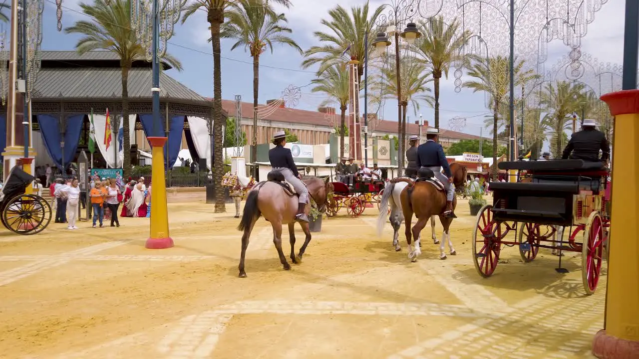 Three people ride horses through fairgrounds at Jerez Horse Fair Spain