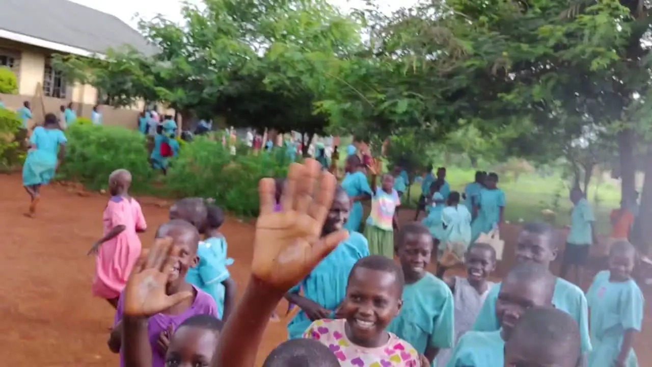 А young traveler takes a selfie with a group of children in a schoolyard in Uganda