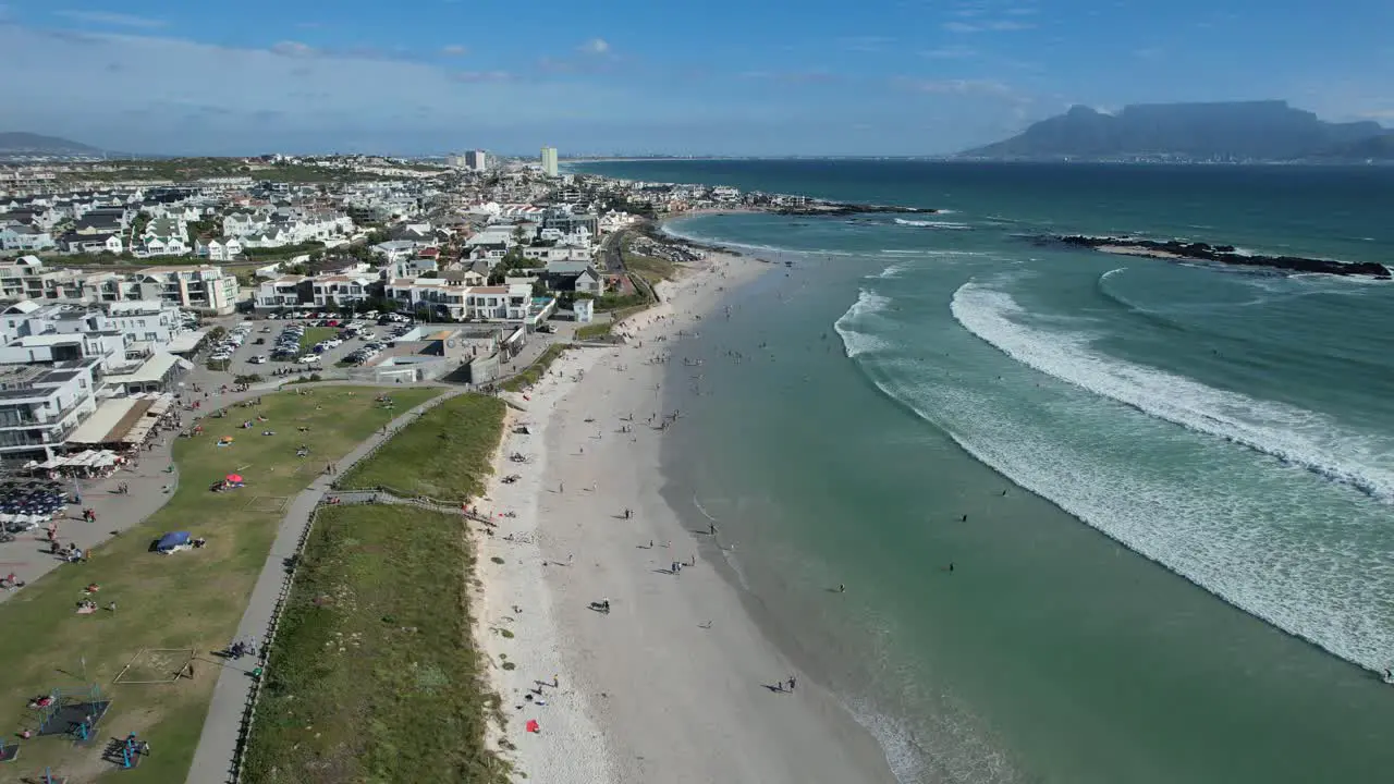 people enjoy summer day at Big Bay Beach in Cape Town South Africa