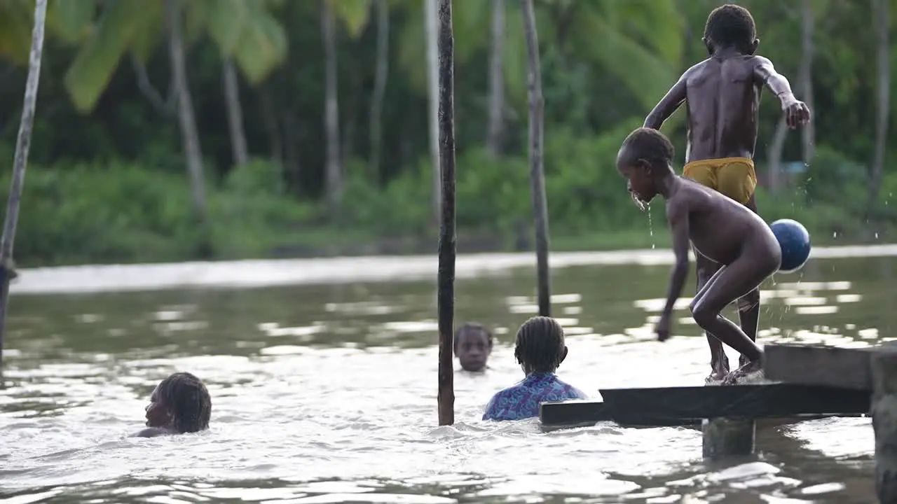 Papuan children play and swim in the river in Asmat Papua