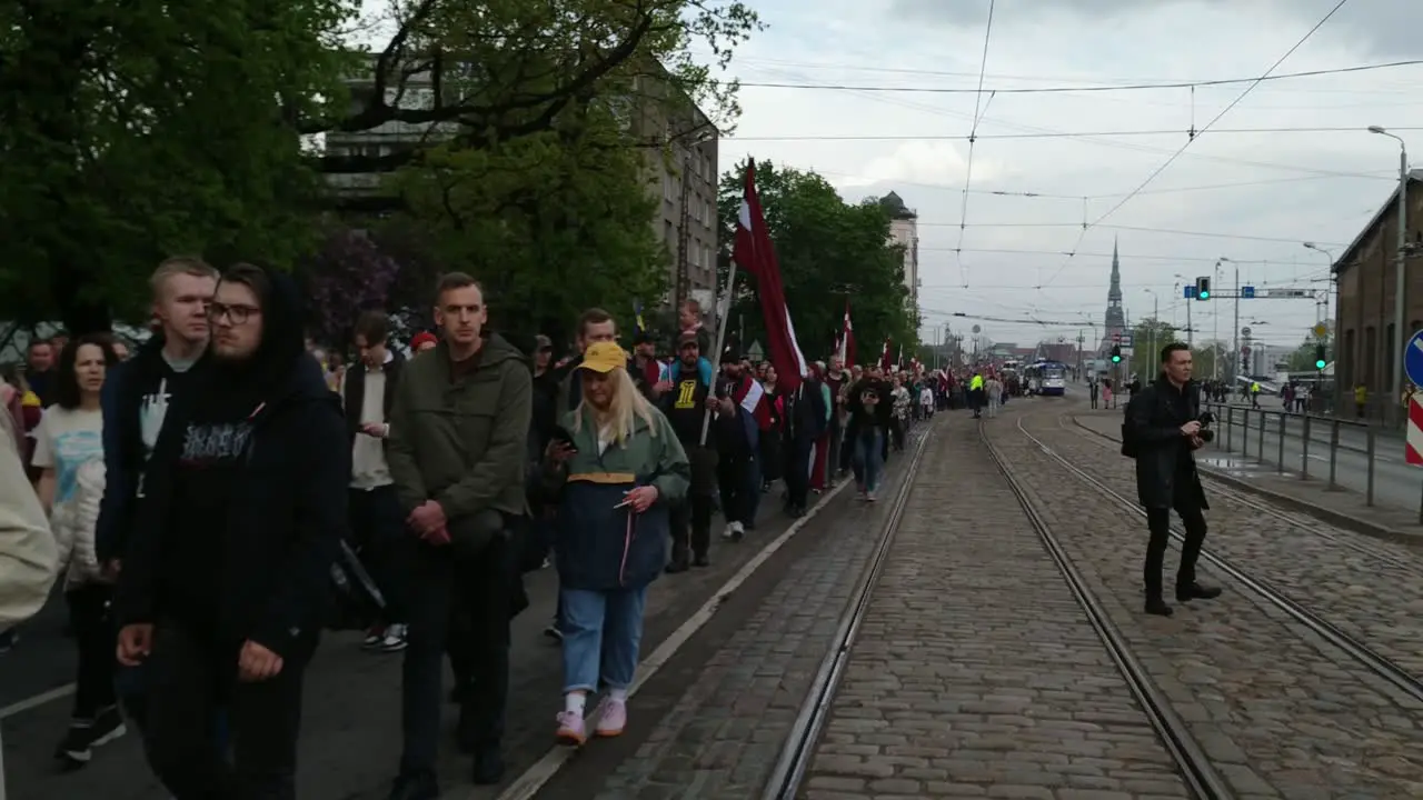 Crowd of People March in Streets of Riga Against Soviet Monument