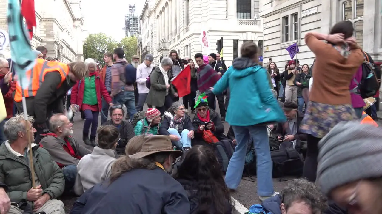 Protesters sit on the floor and sing songs during the Extinction Rebellion protests in London UK