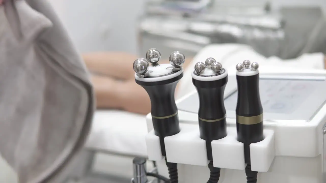 Bokeh shot of electronic massagers with a masseuse preparing the patient in the background