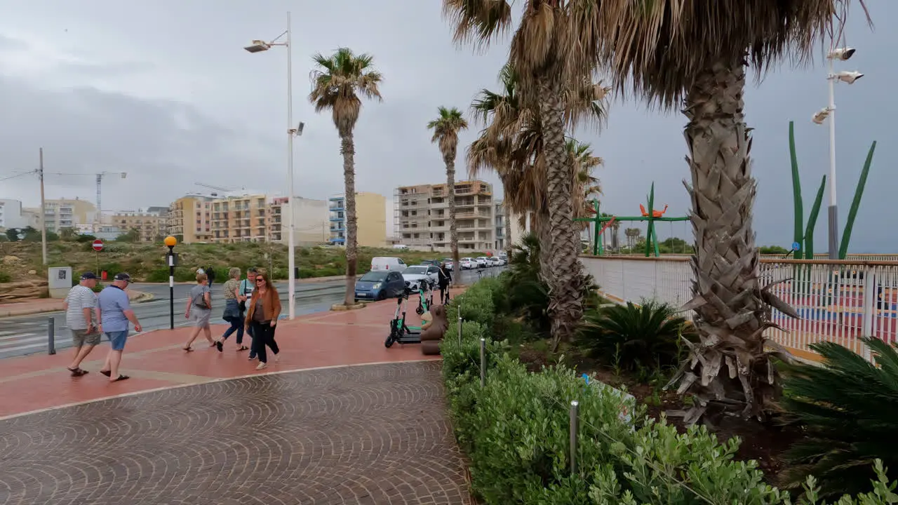 People on walking street strip with palm tree in Valletta Malta during the day