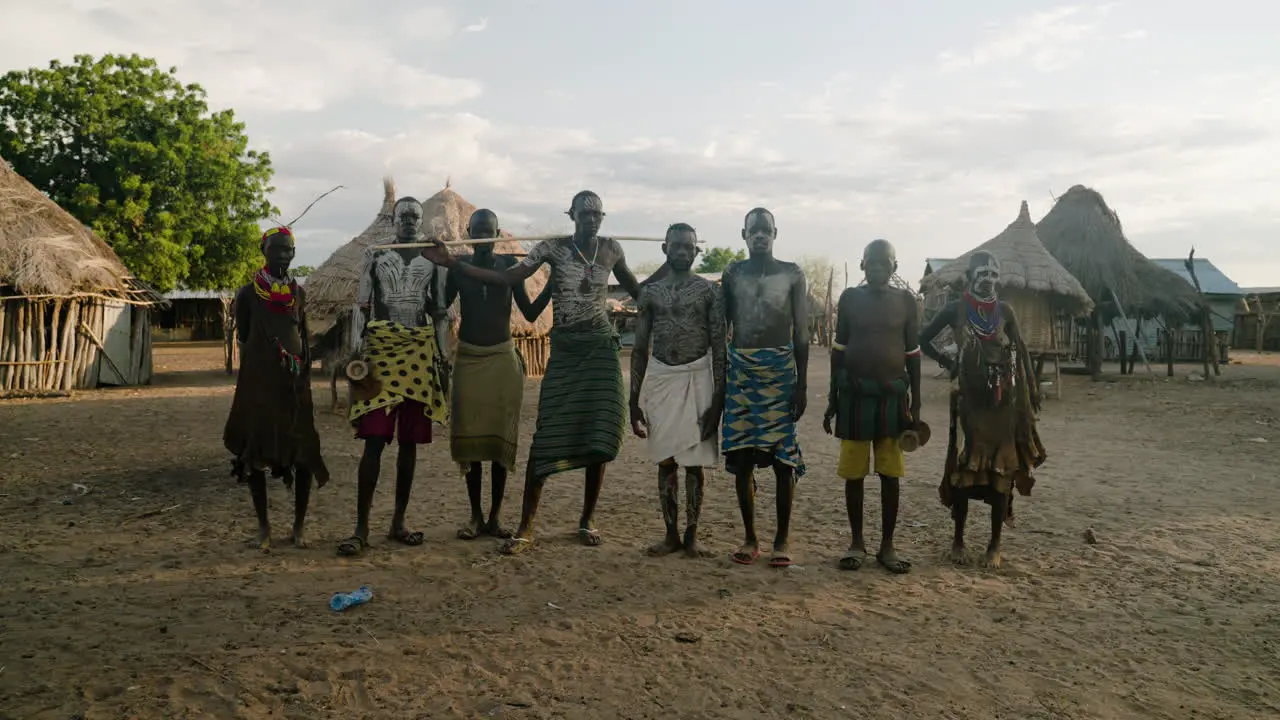 Indigenous People Of Karo Tribe With Body Paint Standing With Thatched Houses In The Background In Omo Valley Ethiopia