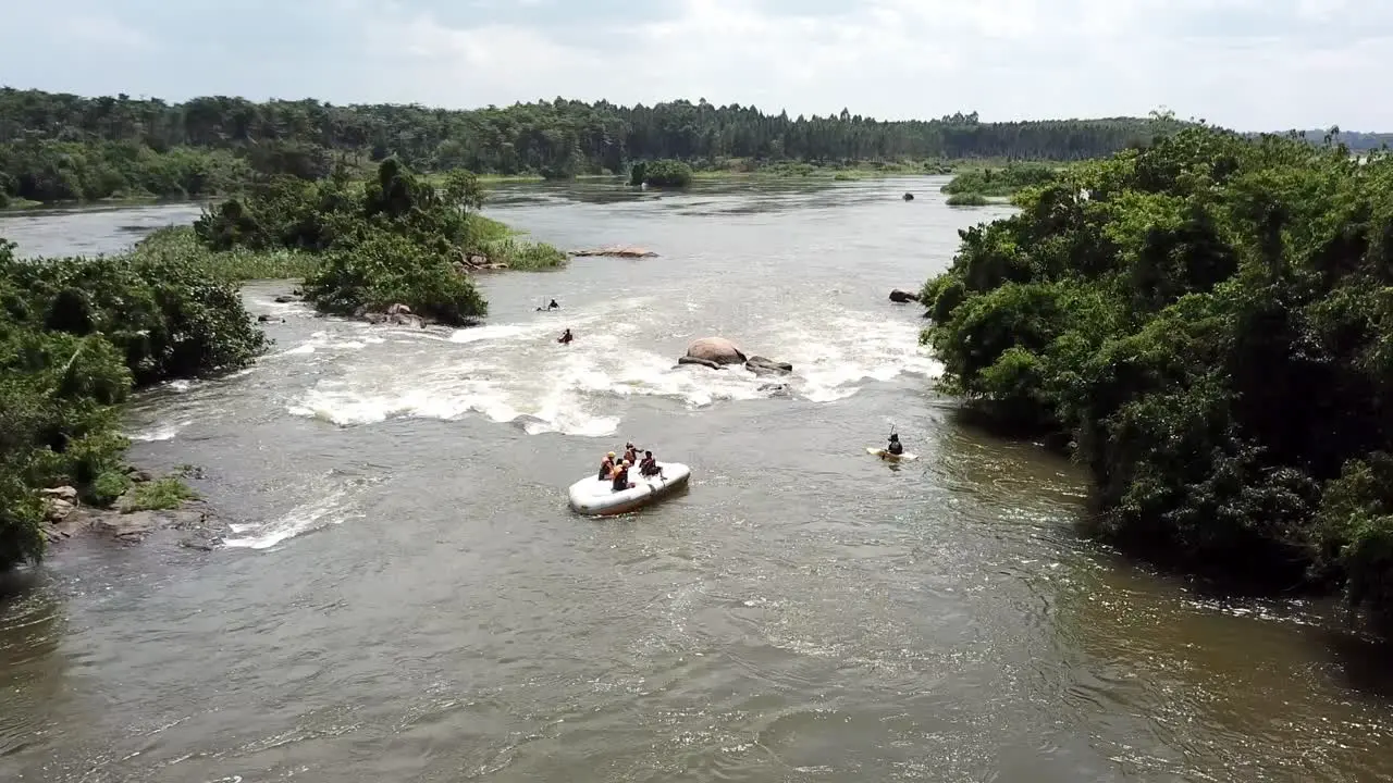 Aerial drone view of an upside down rafting boat with people on top of it on the Nile River in Jinja Uganda