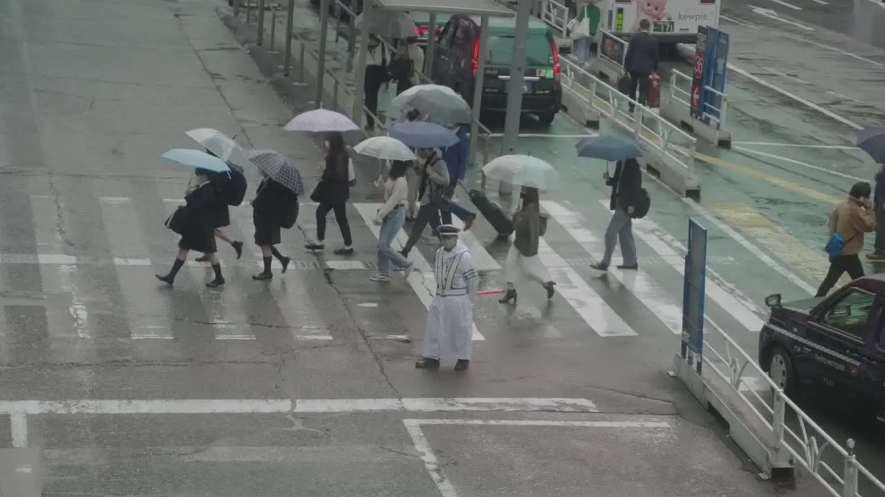 Japanese High School Students Holding Umbrellas Up Crossing The Road Near A Taxi Stand On A Rainy Day In Shibuya Tokyo Japan