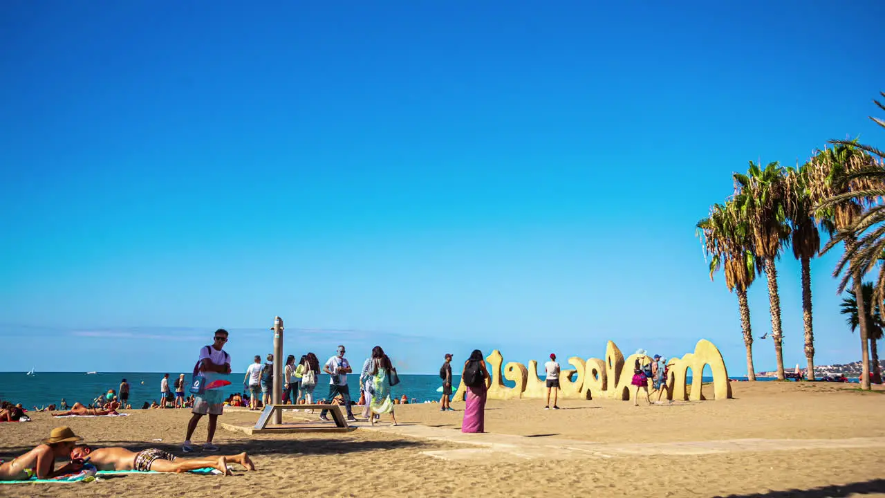 Time lapse people moving on beach close to Malaga sign in Spain Mediterranean Sea