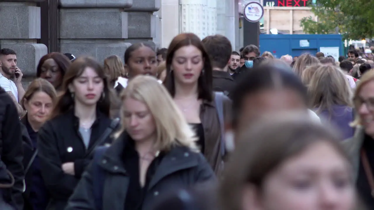 People walk along a busy on Oxford Street during the day