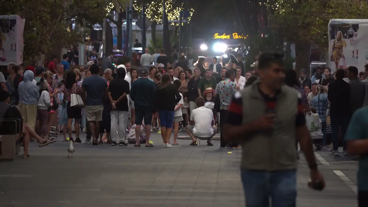 Crowds gathered in a circle in the middle of cavill avenue watching street busking performance at night at surfers paradise Gold Coast Queensland Australia