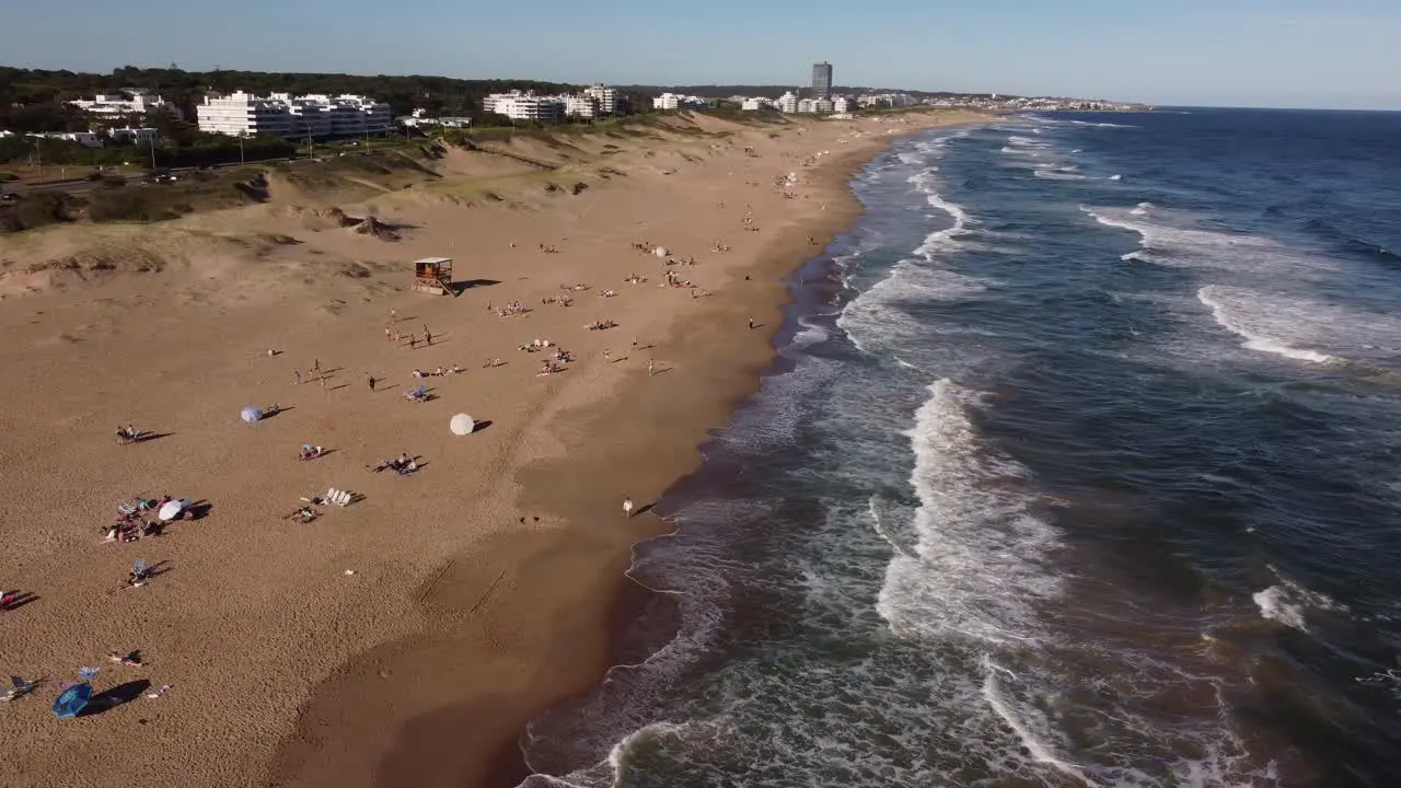 People sunbathe on Playa Brava beach on sunny day Punta del Este in Uruguay