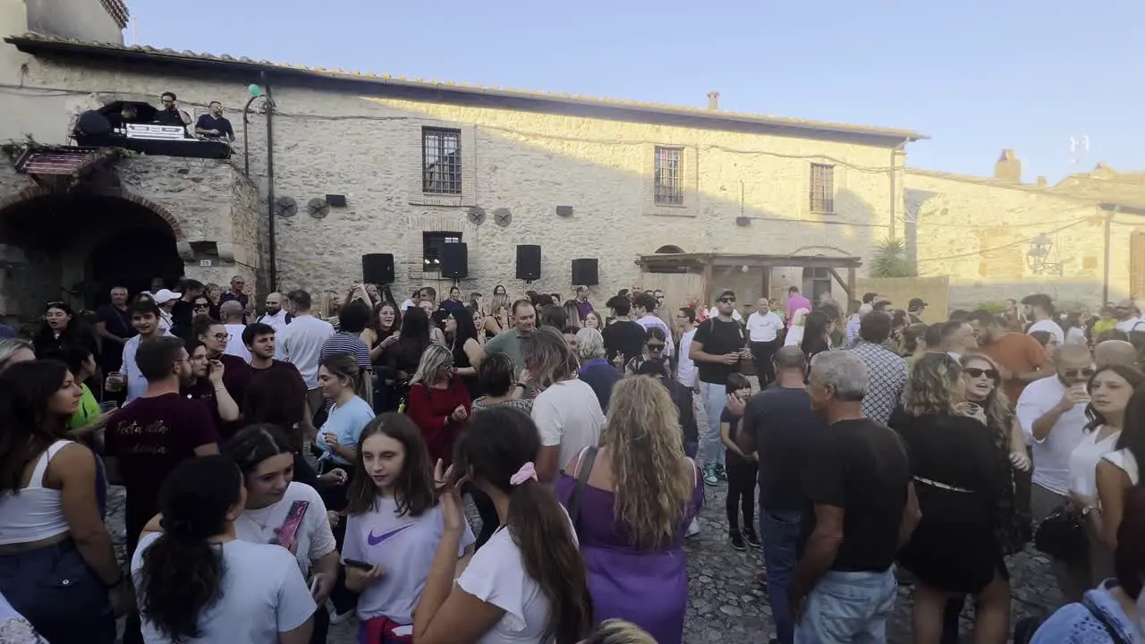 Crowd of people dancing at grape harvest festival of medieval Penna in Teverina town in Italy