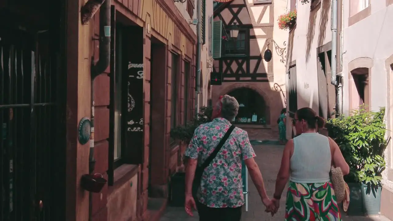 older couple walking hand in hand trough shopping alley in petite france strasbourg