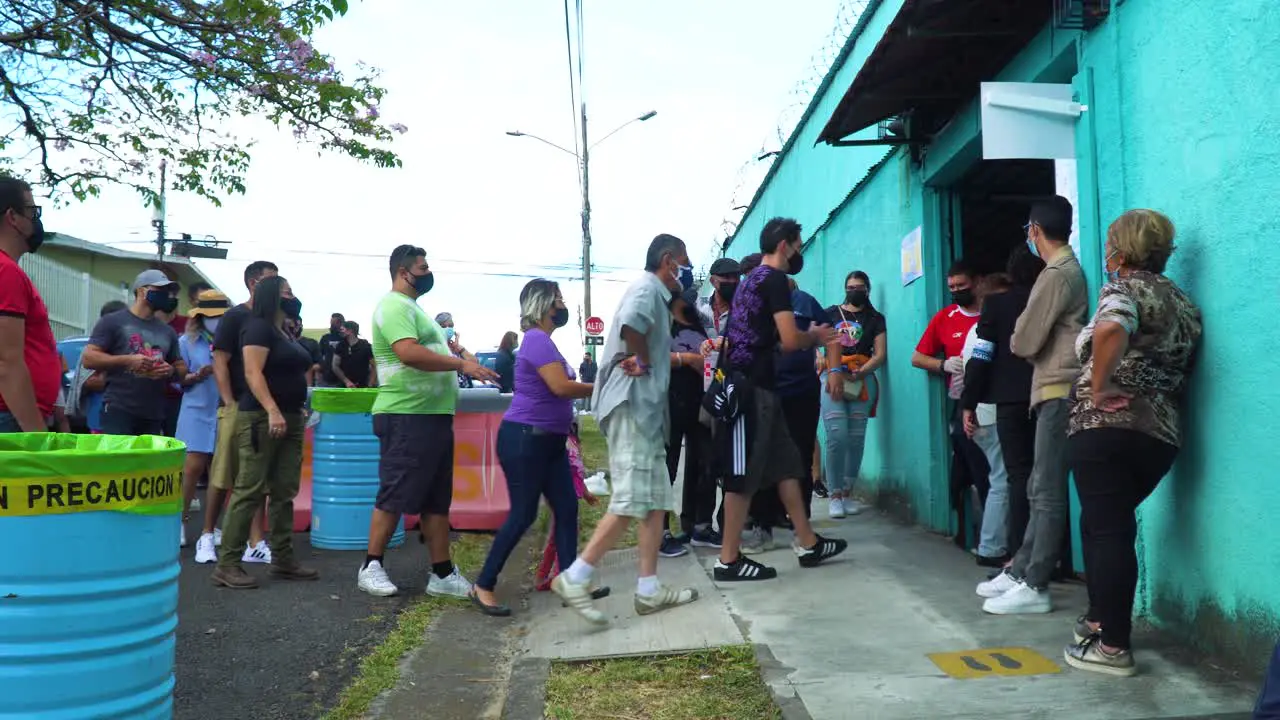 SAN JOSÉ COSTA RICA FEBRUARY 6 2022 Election Day editorial a queue outside the voting station with people standing in line slowly moving to enter