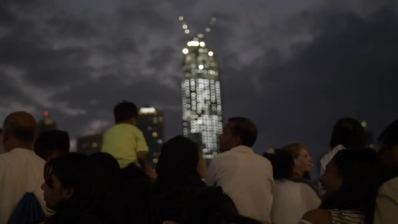 People tourists families at the Dubai mall in Downtown Dubai UAE with skyscrapers and buildings lit up at night