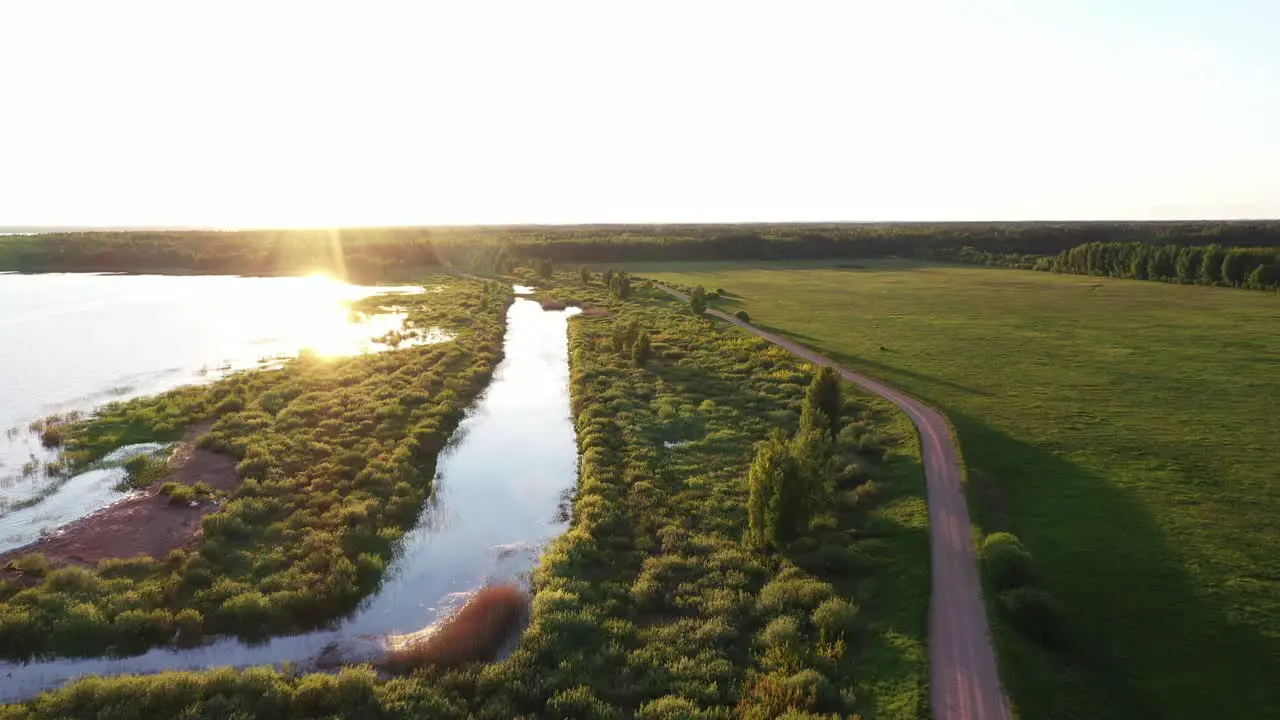 Sun reflection on lake water in Latvia landscape aerial fly forward view