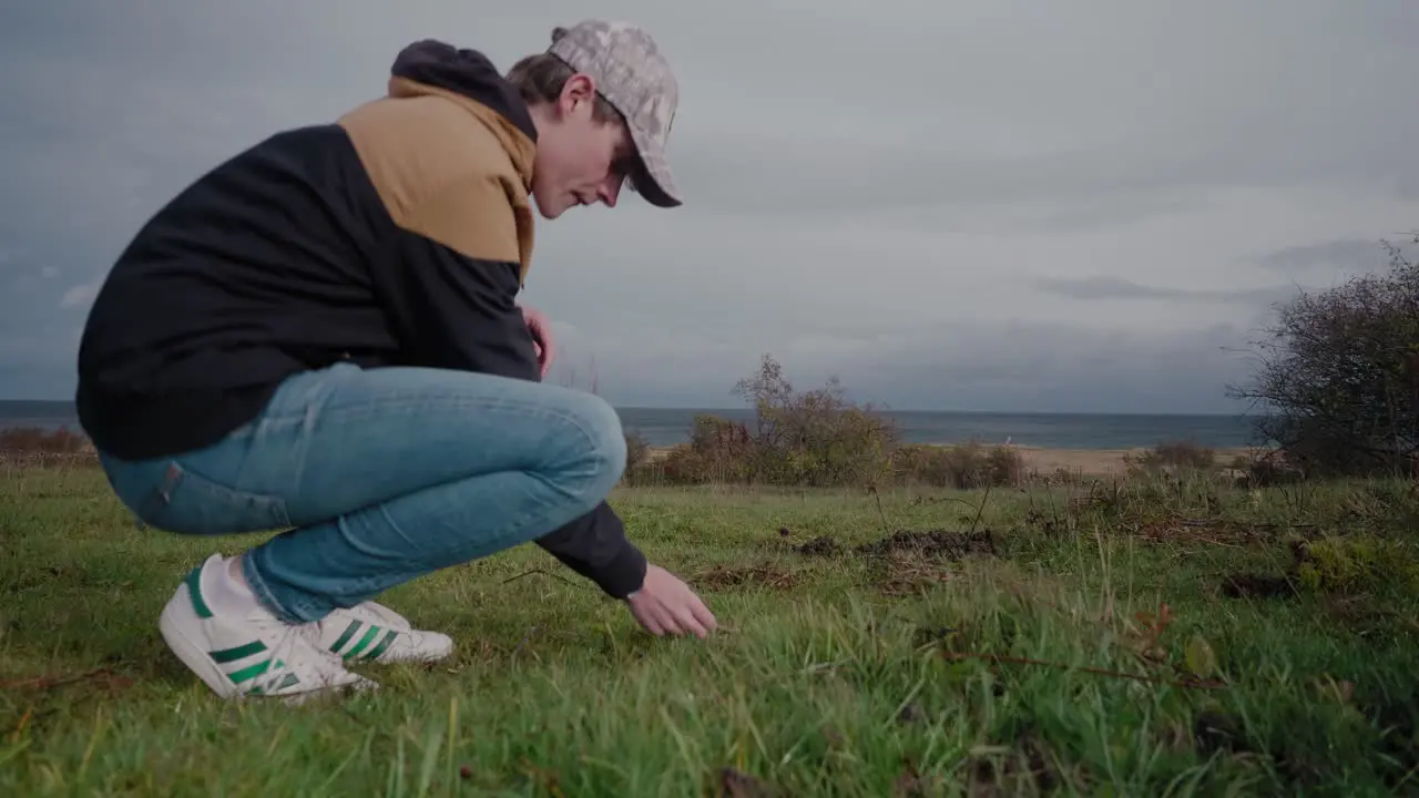 Young and Tall Biologist Finds a Mushroom in Vårhallarna Simrishamn Sweden and Throws it Away Tracking Medium Shot To Wide Shot