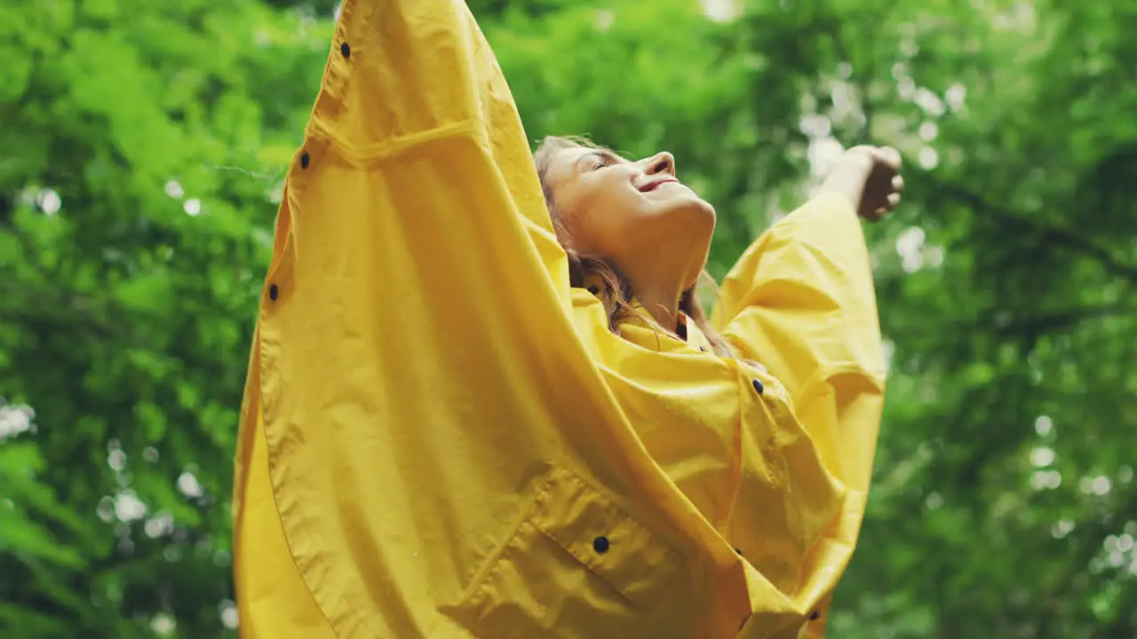 View From Below Of A Happy Girl In A Yellow Raincoat