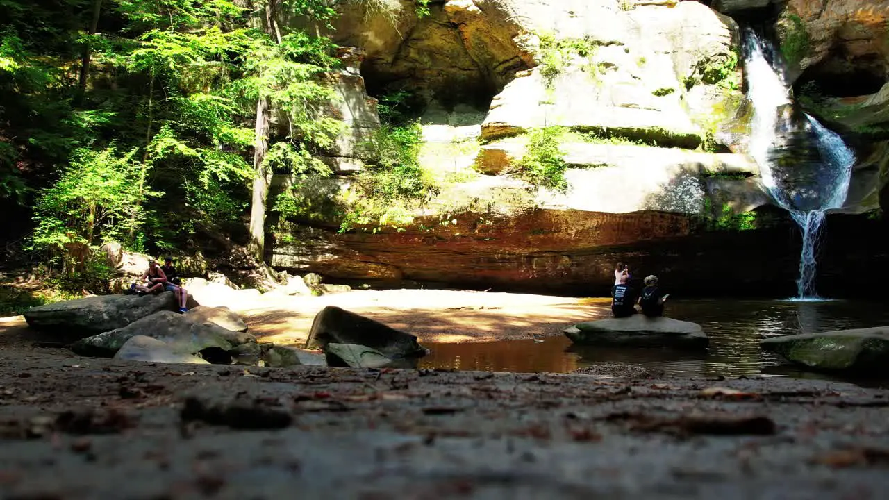 Ground level shot of a beautiful waterfall with a few hikers enjoying the view