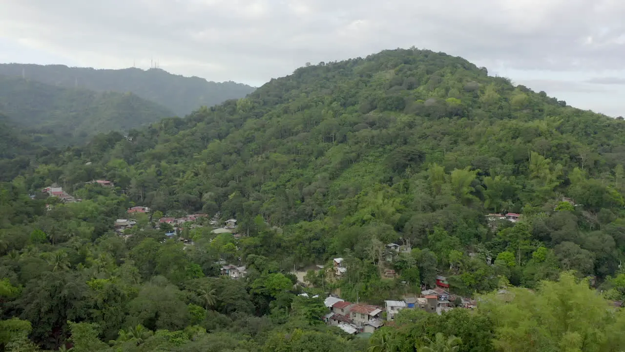 Drone video from above with houses built in green jungle in a Southern Asia