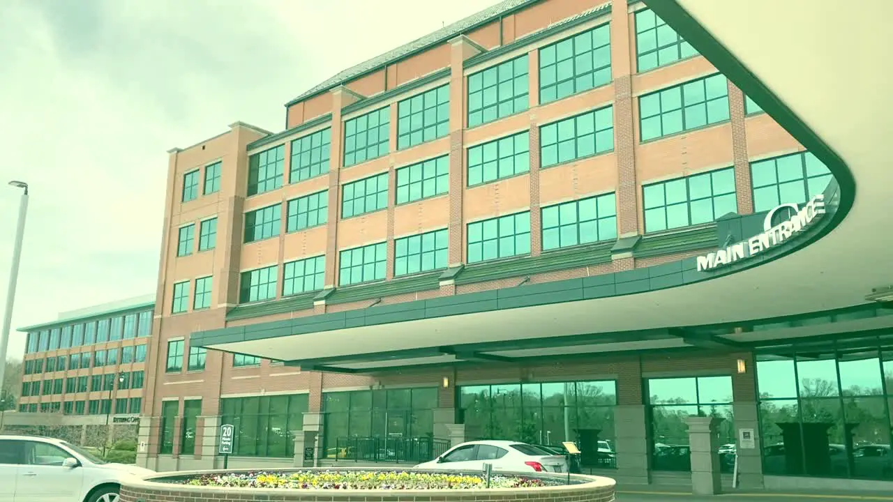 HD steady shot of main hospital entrance showing light traffic