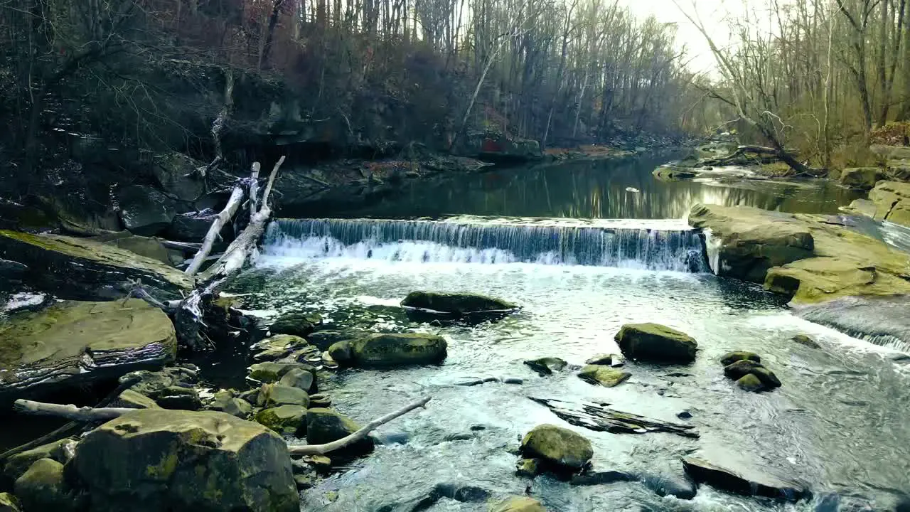 Small park waterfall with logs and rocks