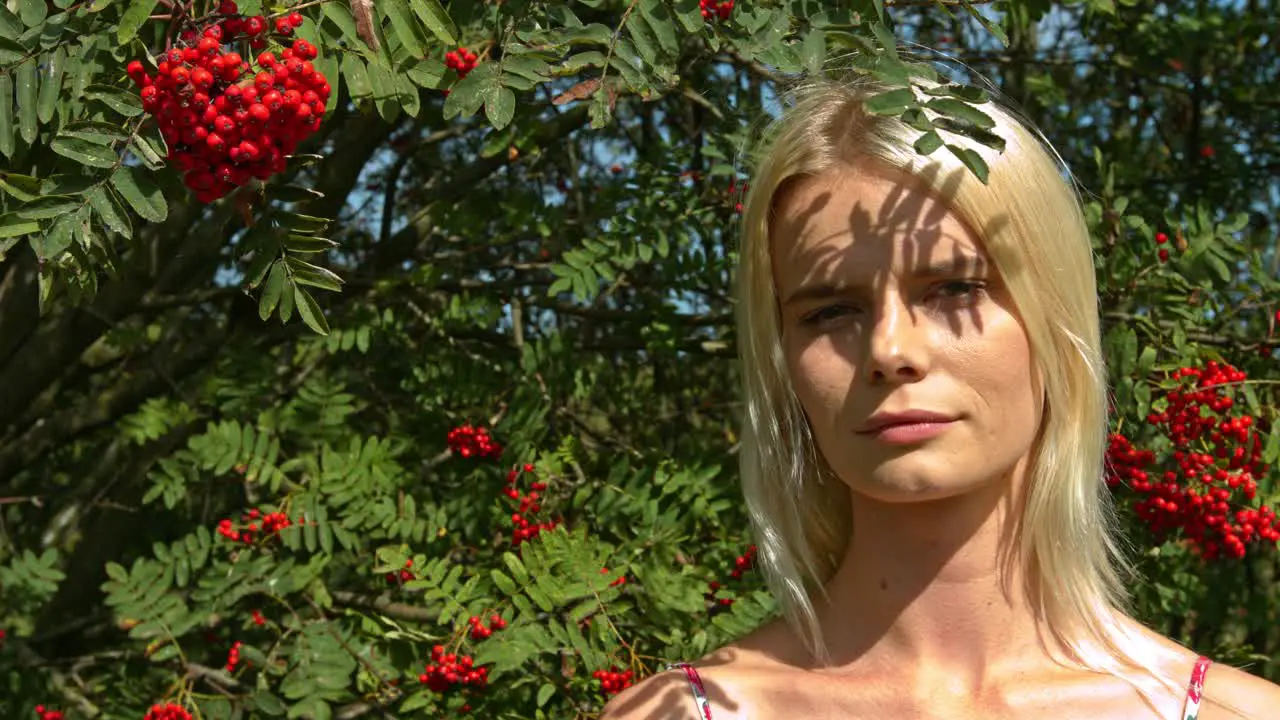 In summertime A lady standing outside in the shadow of a flowery nature