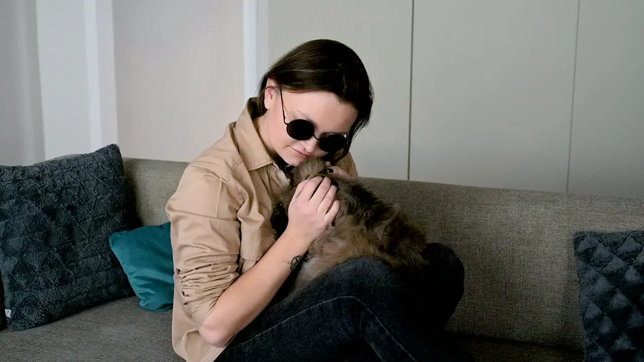 Blind Woman In Sunglasses Sitting On Sofa At Home And Petting Her Cat 3