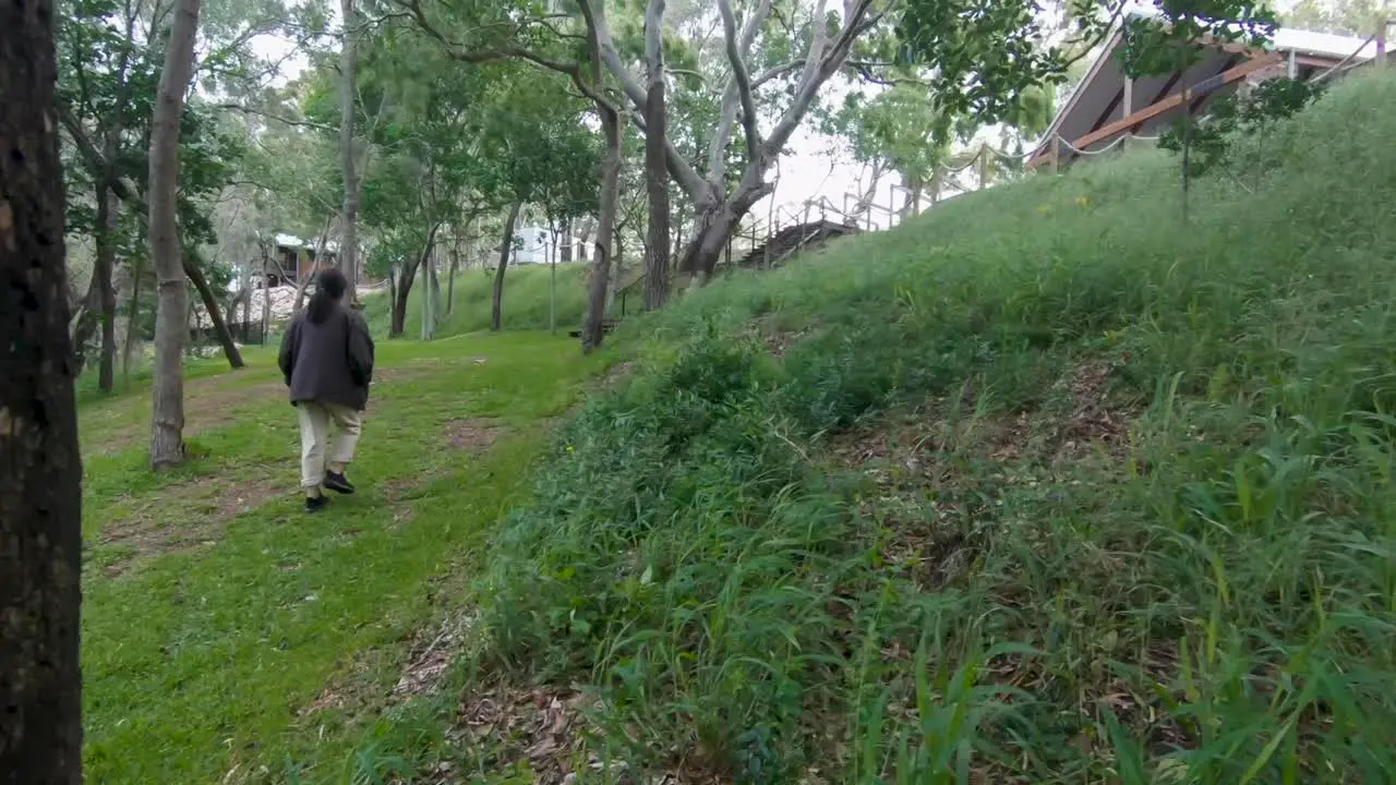 Female walking through a forested green neighbourhood