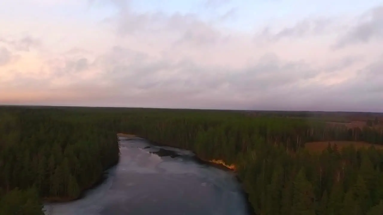 Drone shot of forezen river in green forest