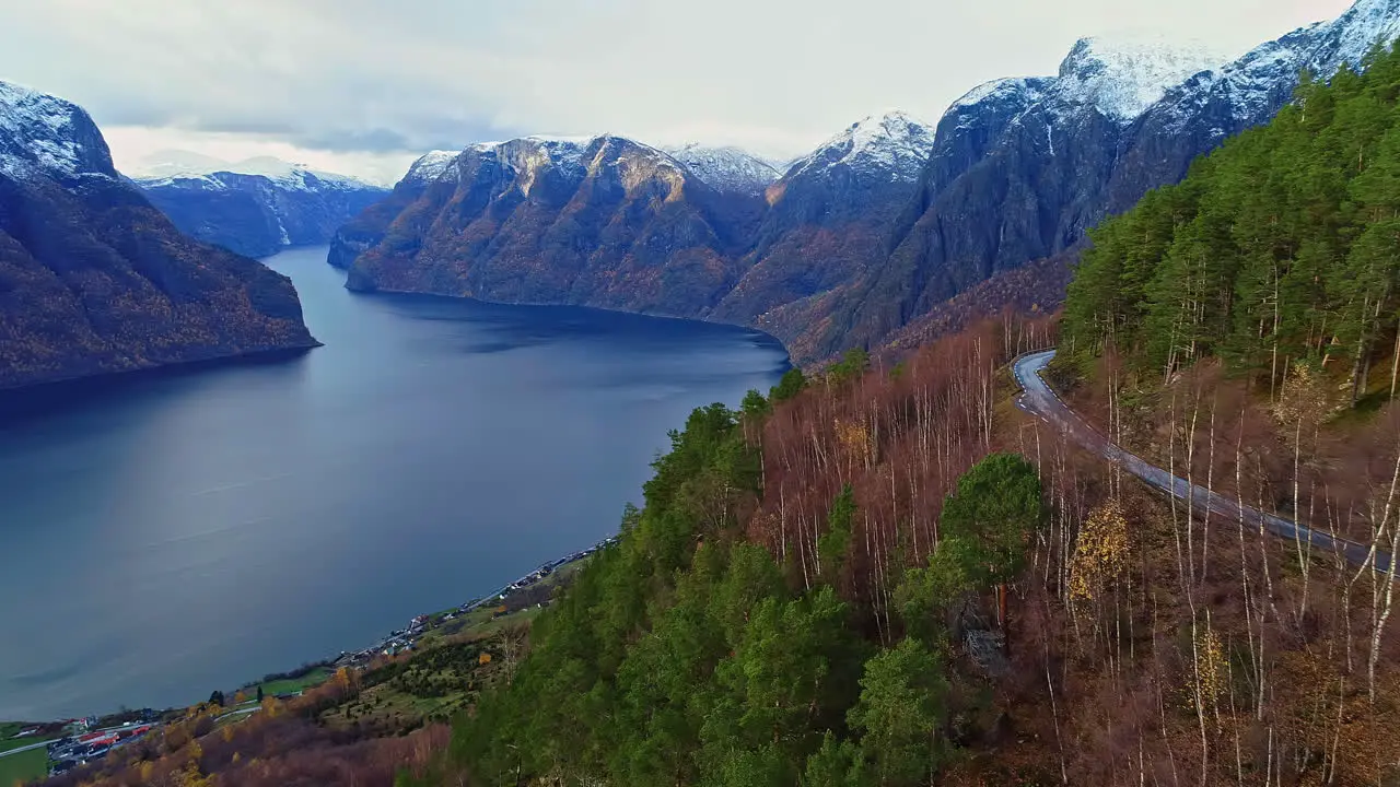 Dangerous mountain side road and majestic lake aerial drone fly forward view