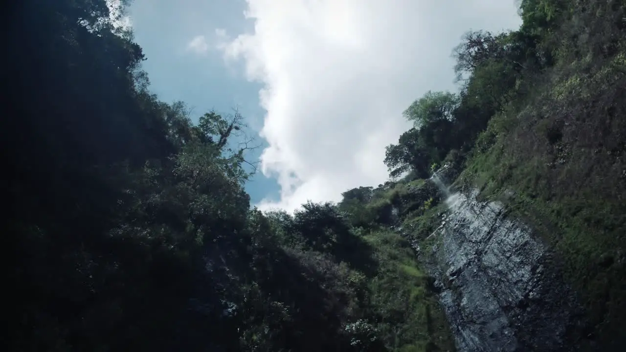 Looking up at a waterfall with a sunflare