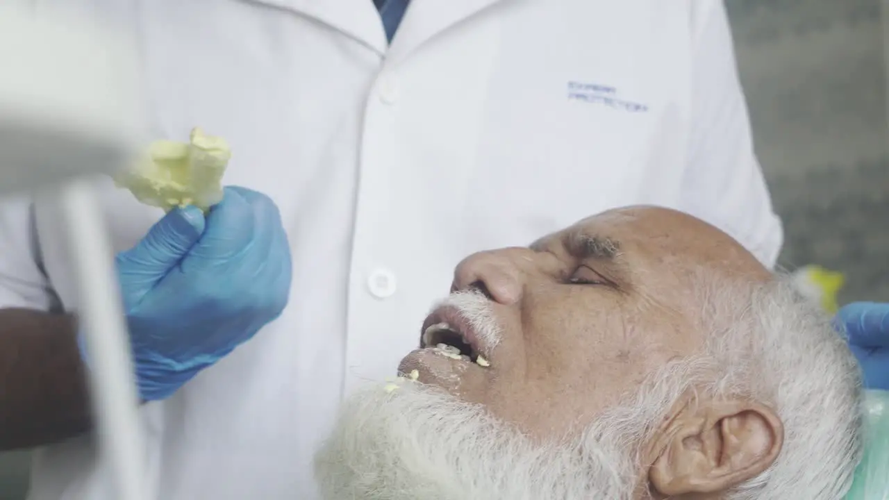 Old man teeth measurement process done by dental surgeon