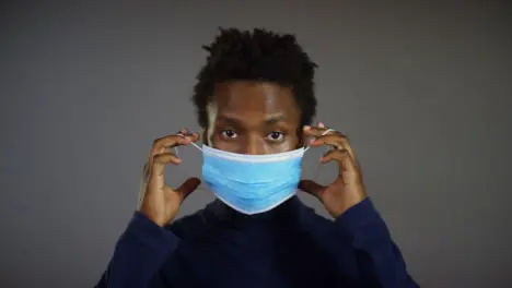 Young Man Putting Face Mask On