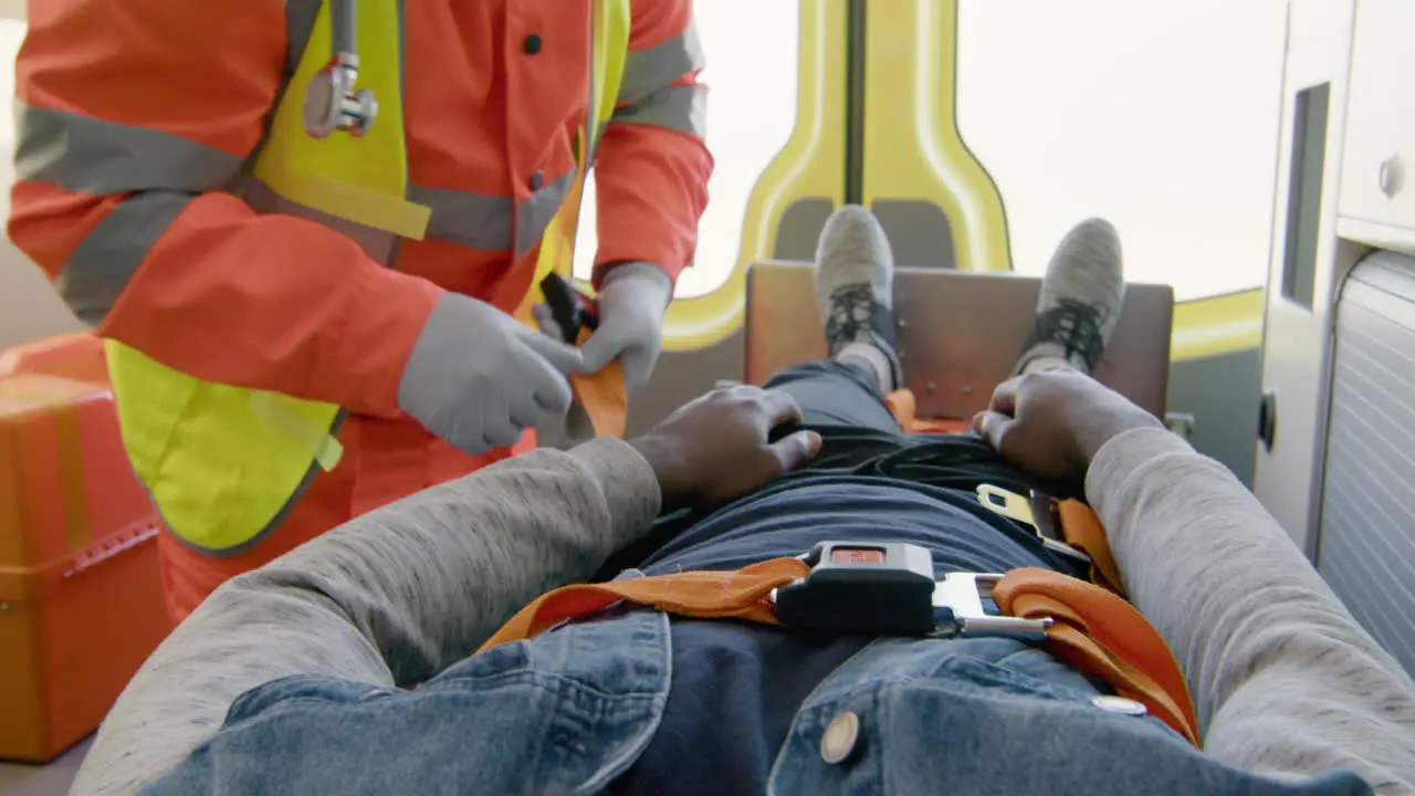 Hands Of A Paramedic Fastening The Seat Belt Of A Patient Lying On The Stretcher Inside An Ambulance