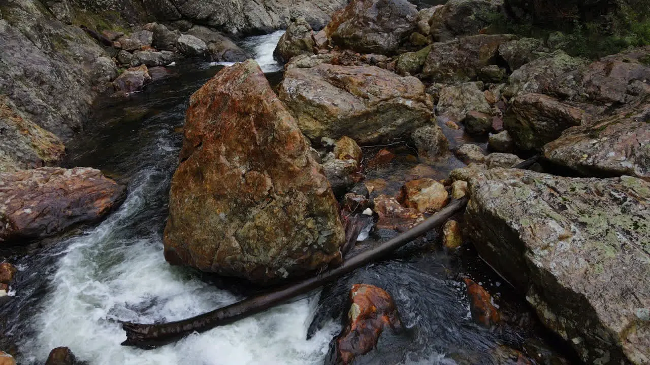 Slow Drone skimming along river in Gorge New Zealand with bushland trees rocks and water Pt 2