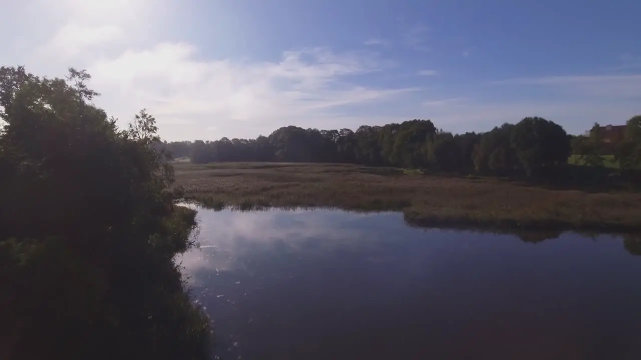 Flying Low Forwards Over The Winding River on a Sunny Morning