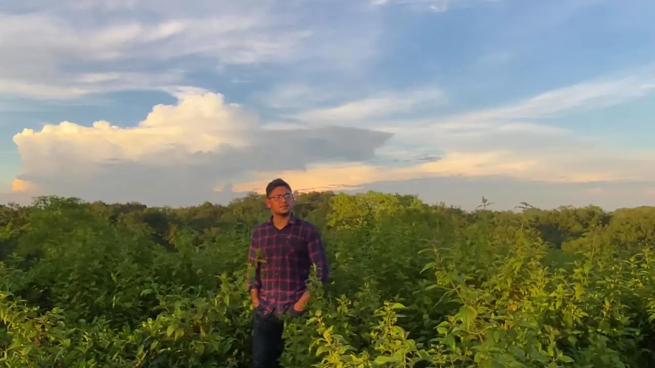 Alone young man enjoying and witnessing sunrise over a hilltop forest at morning