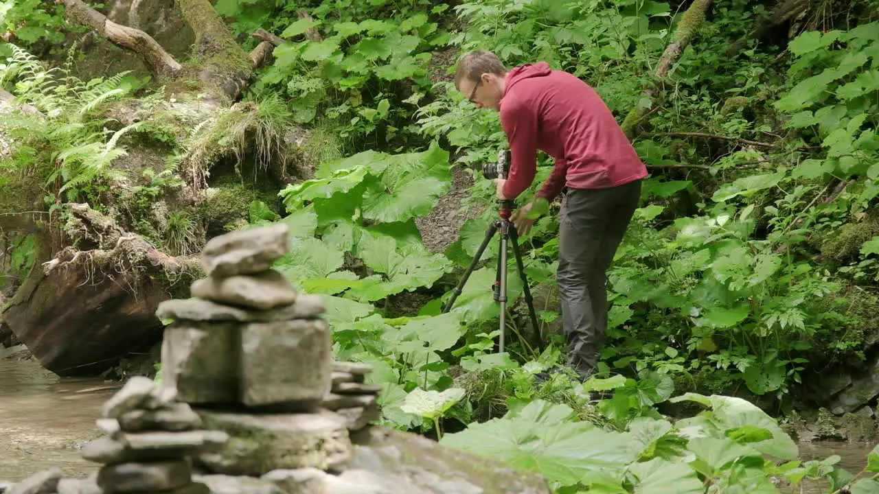 Photographer putting his camera on his tripod and setting up to capture a photo in nature