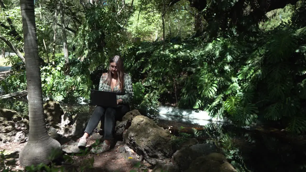 Student learning on her laptop in the park