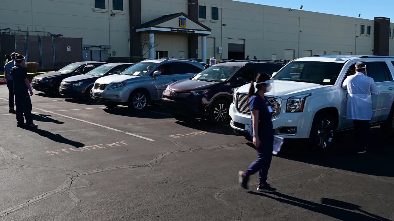 Medical worker walks by cars at Covid-19 vaccine site