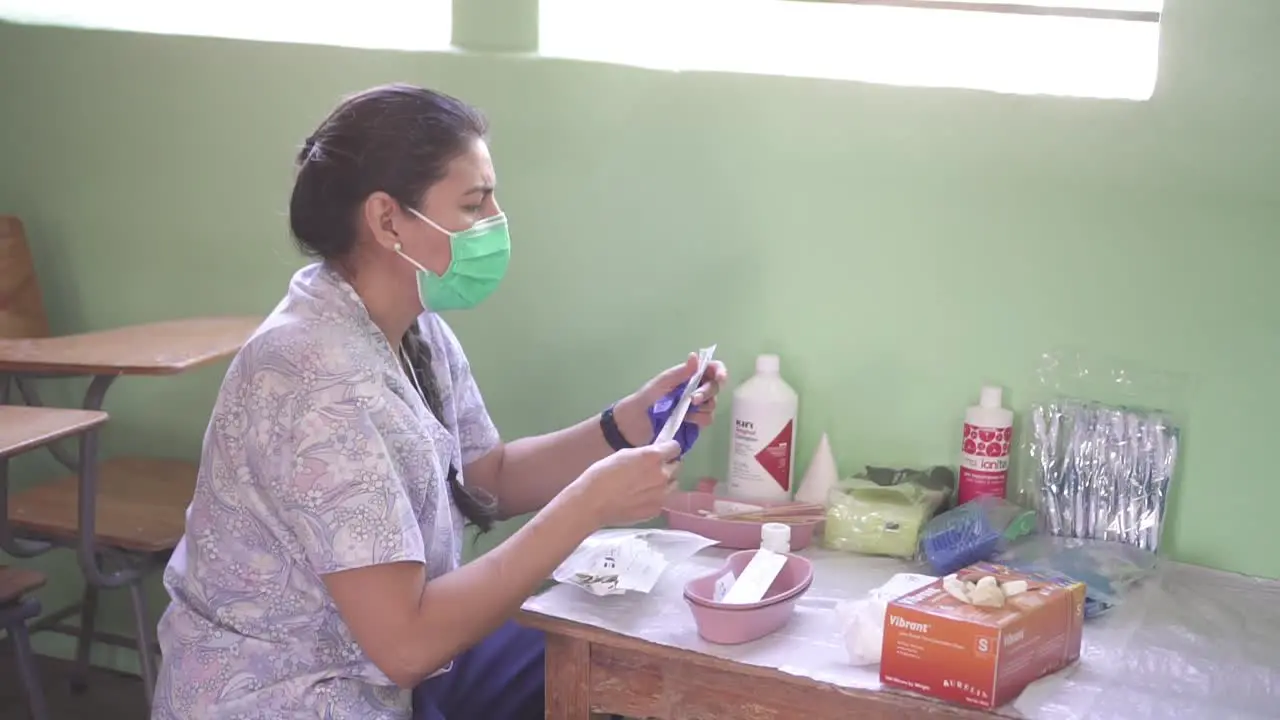 A female doctor prepares supplies instruments and equipment to care for patients during a medical brigade in a poor community in an improvised clinic in a school