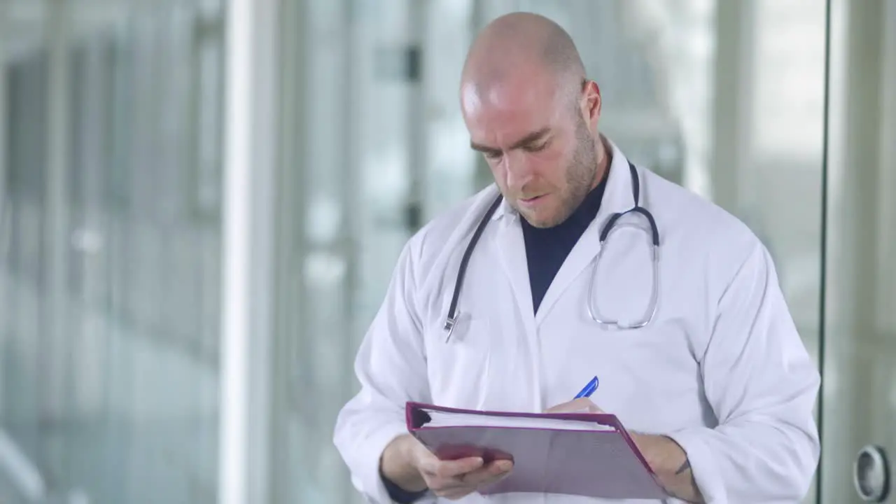 A attractive male doctor is taking notes in a medical center